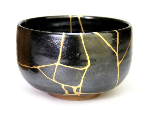 un bol Kintsugi noir avec des cicatrices dorées rectilignes pour illustrer la résilience
